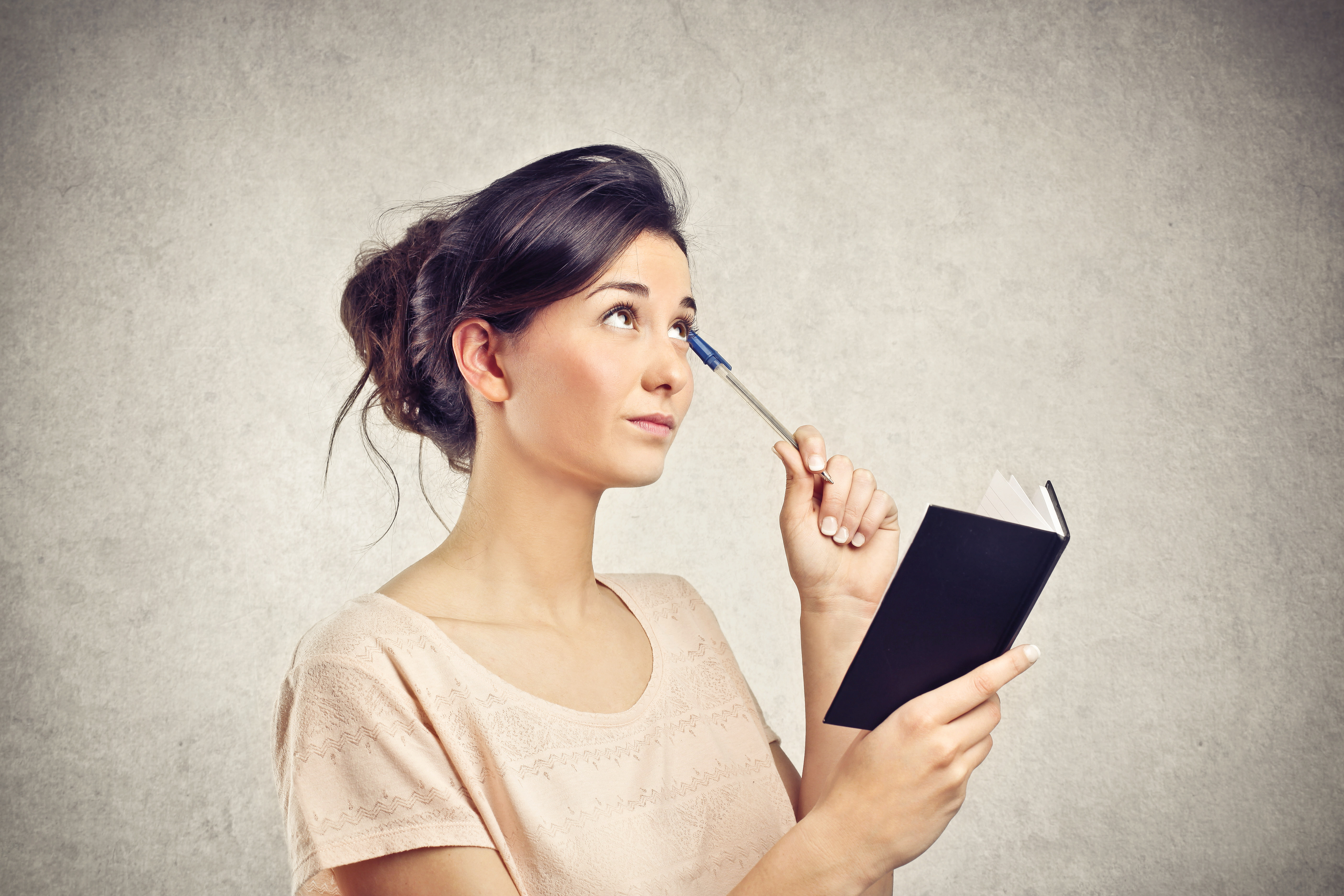 woman with notebook thinking