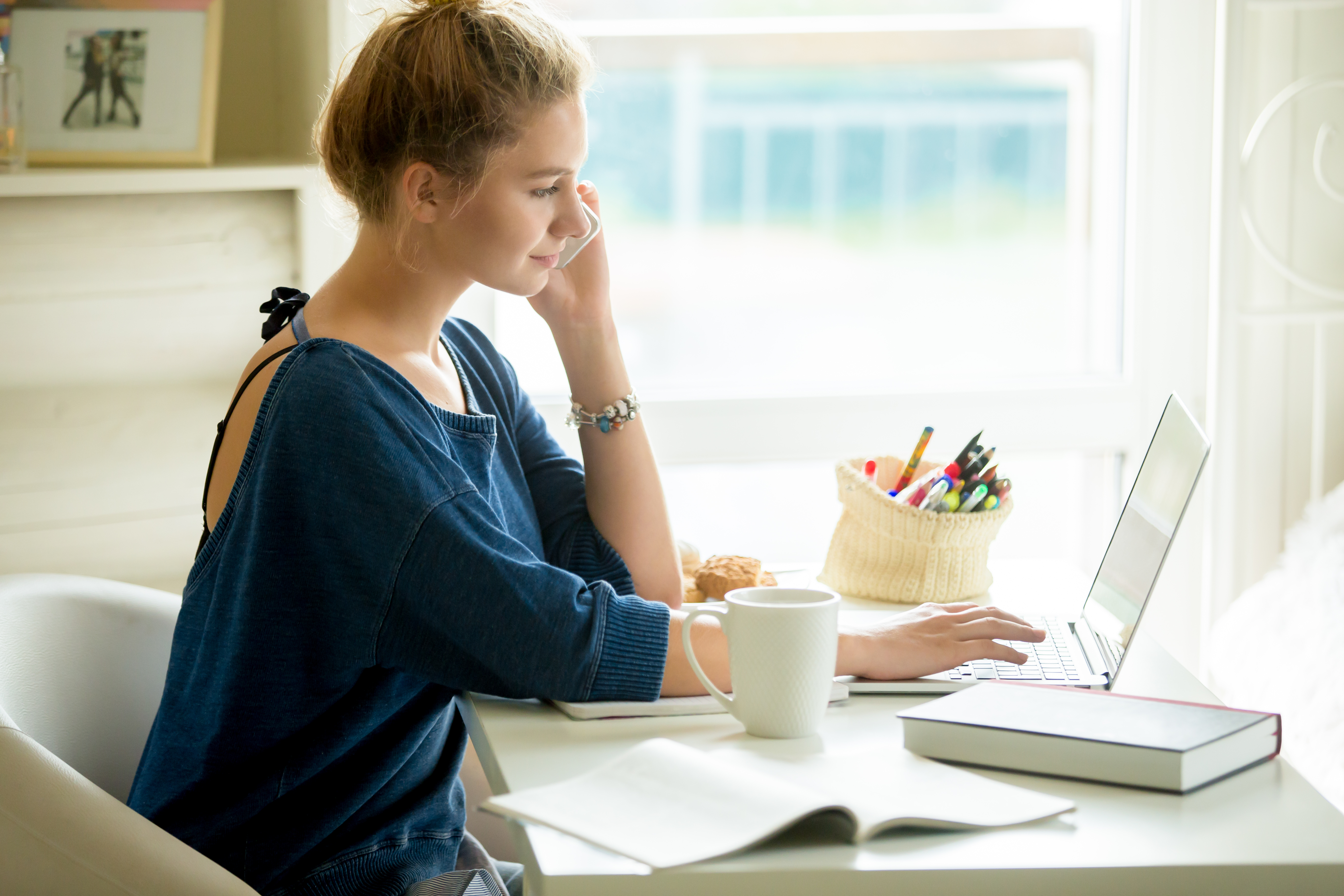 young woman sitting and typing at desk.