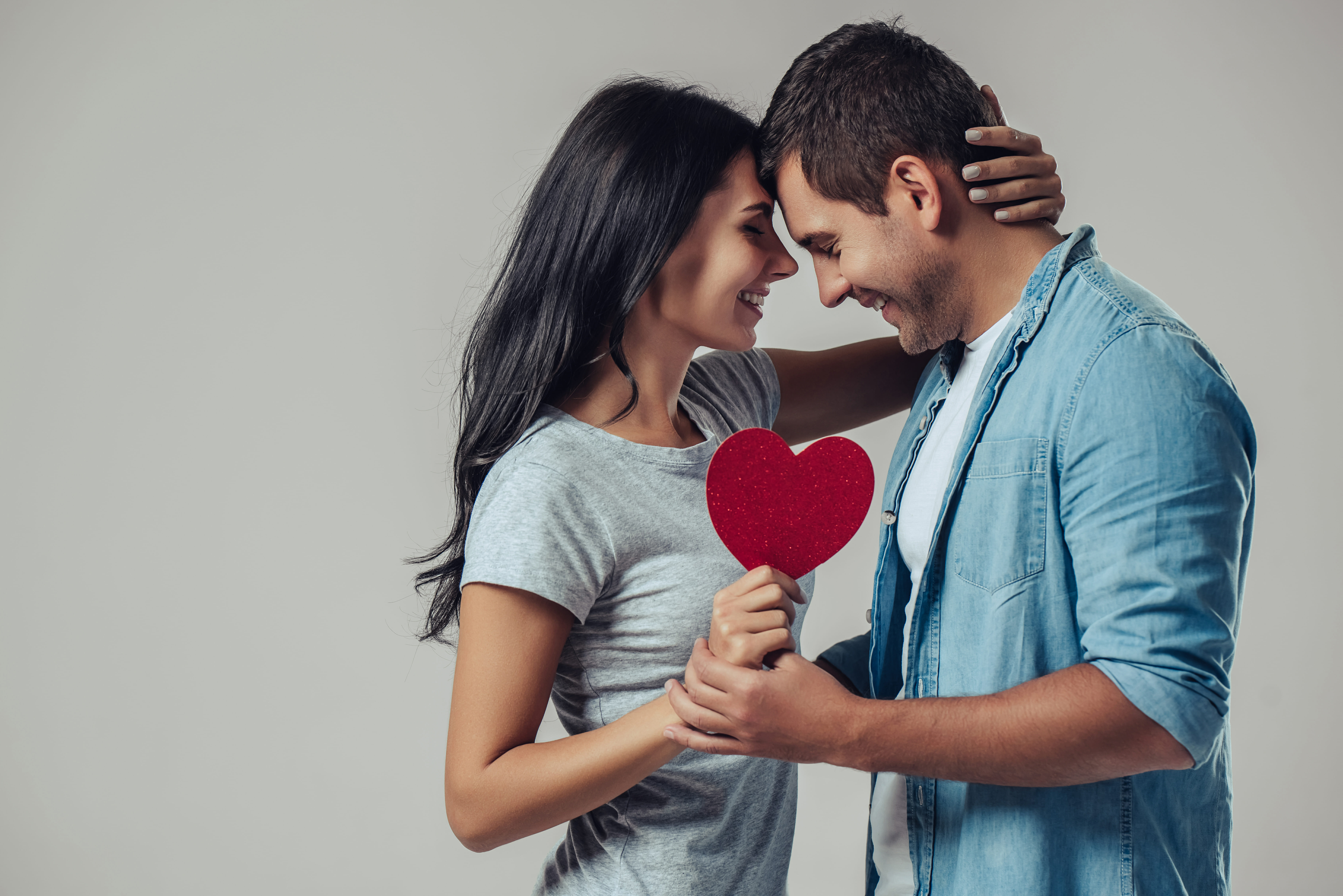 Couple standing face to face with red heart in the middle